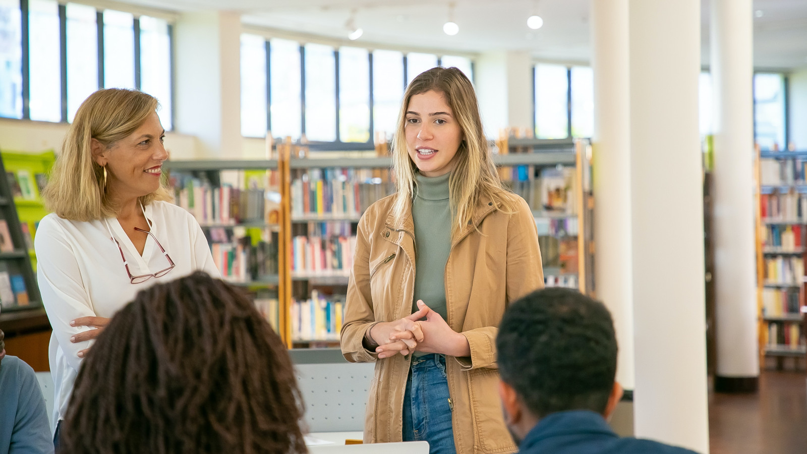 Woman smiling at other woman explaining a topic