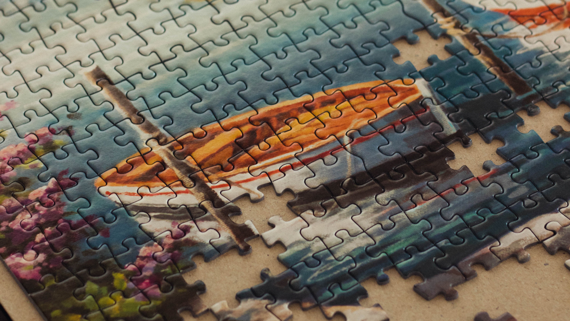 A jigsaw puzzle showing a rowboat, some pieces are still missing
